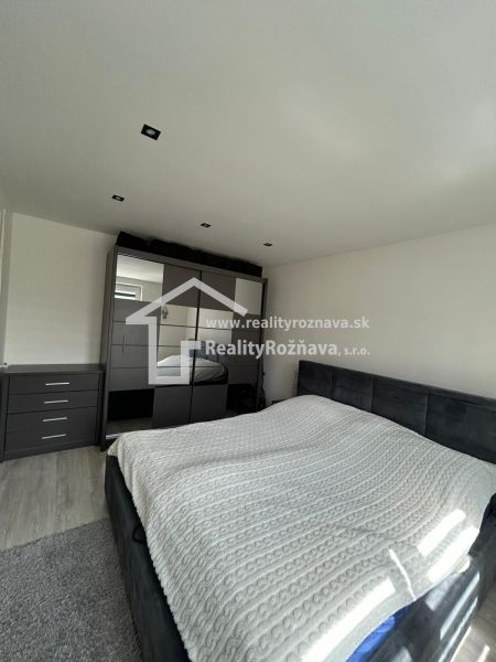 A double bed in the bedroom, a wardrobe with a large mirror, a floor with a wooden decor.