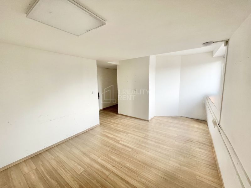 The interior of an office with white walls and a floor with a wood decor.