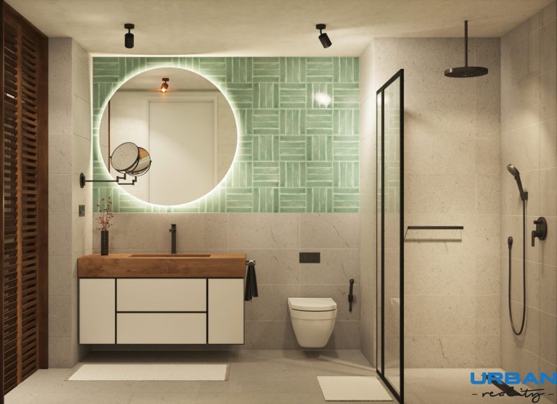 A bathroom with a round mirror, green tiles, and a shower in a 2-room apartment.