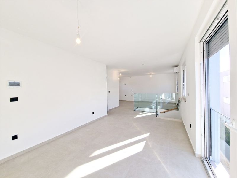 A bright room in a 3-room apartment with white walls and large windows.