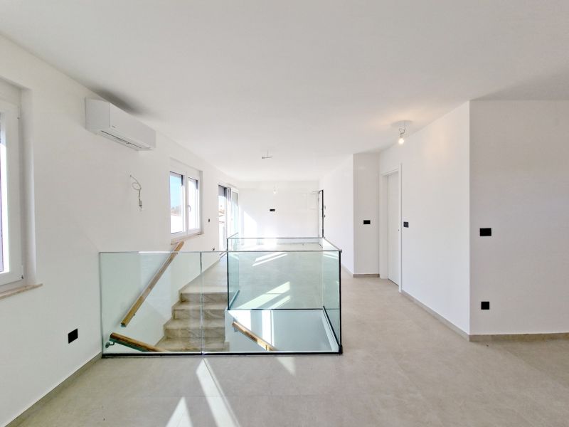 Interior of a 3-room apartment with glass railings and large windows.