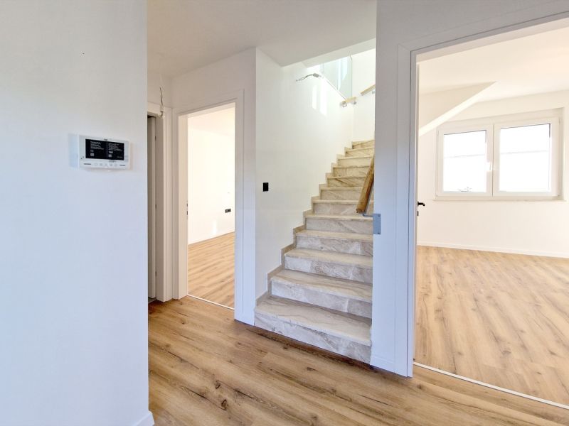 The 3-room apartment has a wooden decor floor and a staircase.