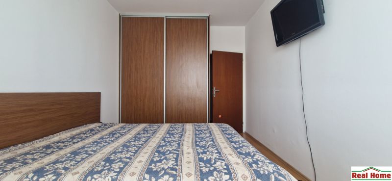 A bedroom with a large built-in wardrobe in a 2-room apartment.