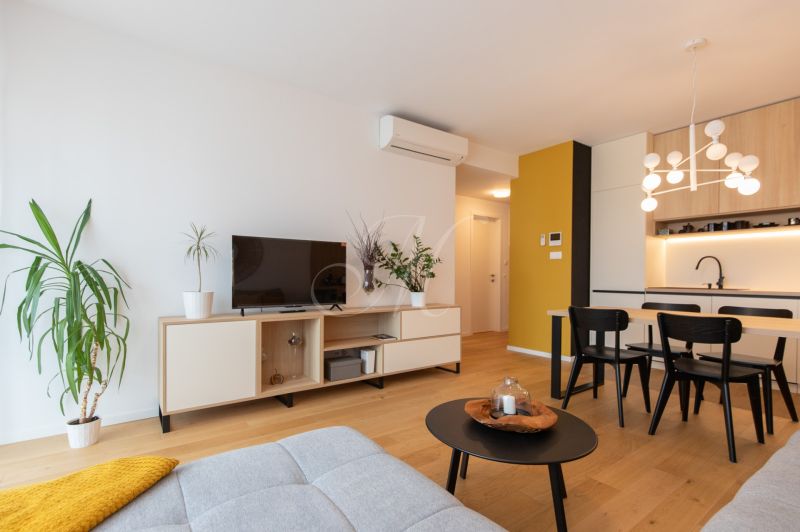 Living room in a two-room apartment with a wooden decor floor and modern furniture.