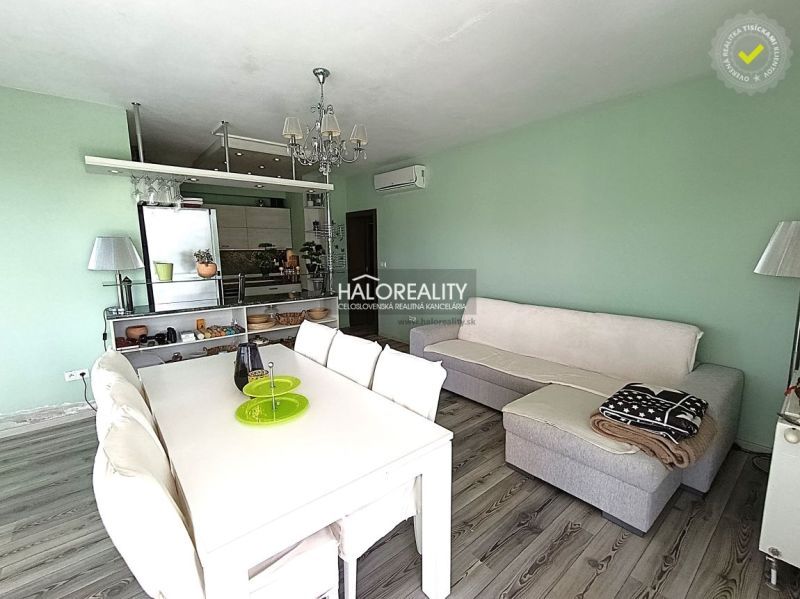 Living room in a three-room apartment with white furniture and a wooden decor floor.