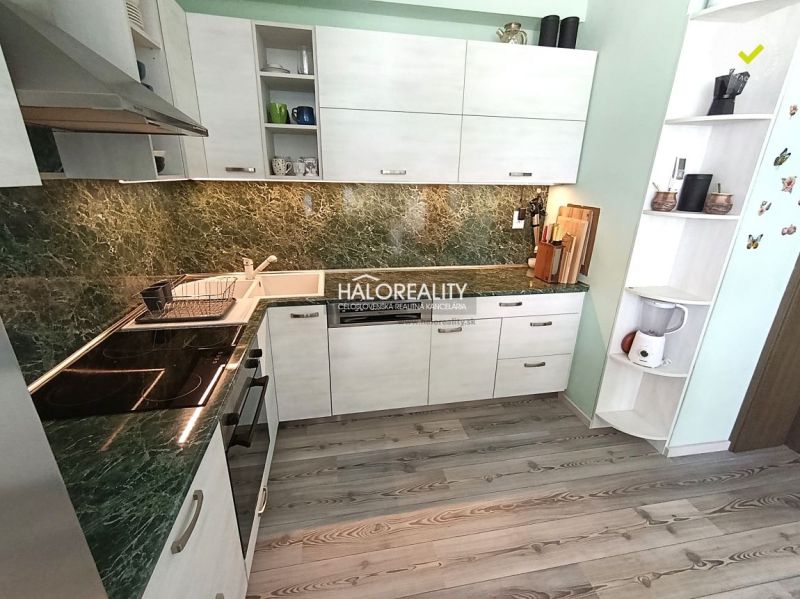 A kitchen in a 3-room apartment with a wooden decor floor and a green granite countertop.