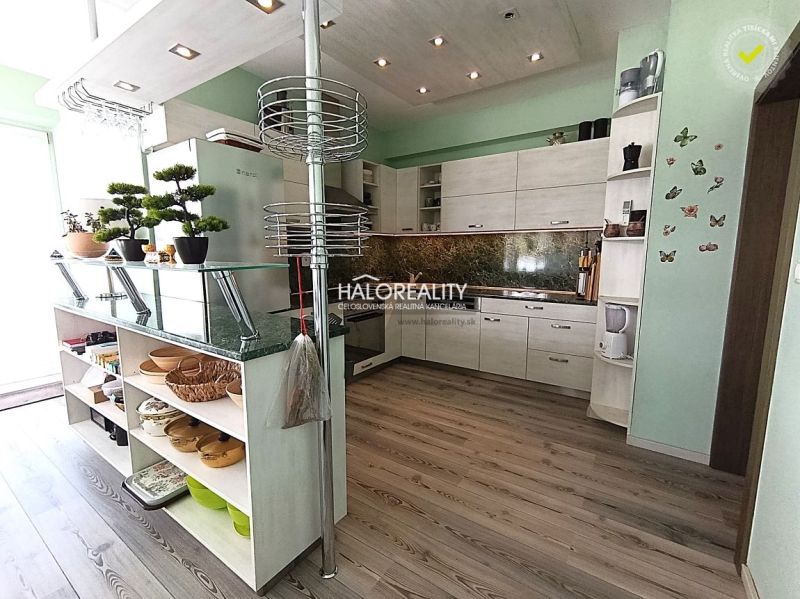 A kitchen in a 3-room apartment with a wooden decor floor and modern cabinet arrangement.