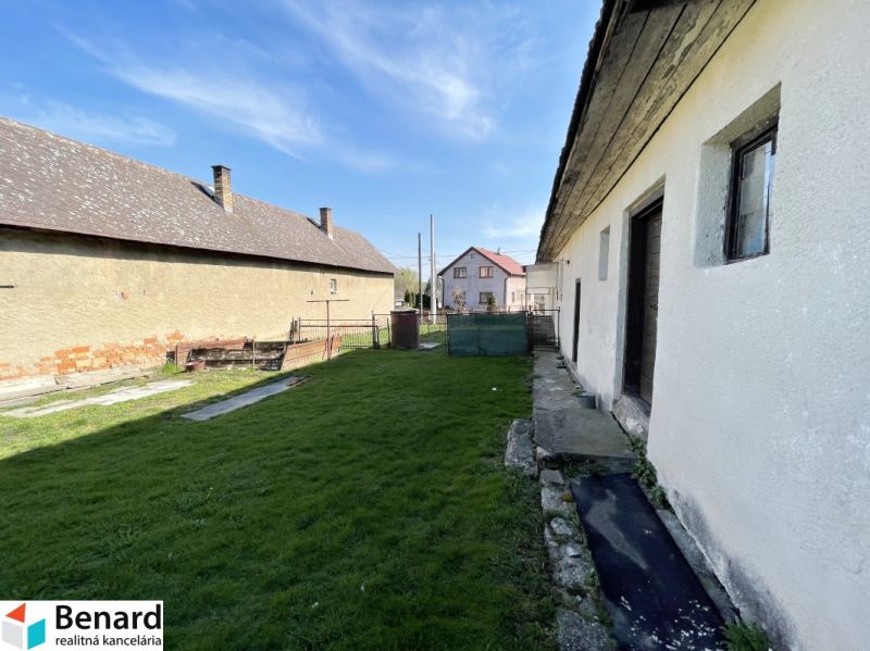 The garden at the family house on Tehelná in Drienov with a grassy plot and visible structures.