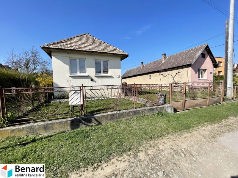 A family house on Tehelná Street in Drienov with a fenced yard and a blue sky.