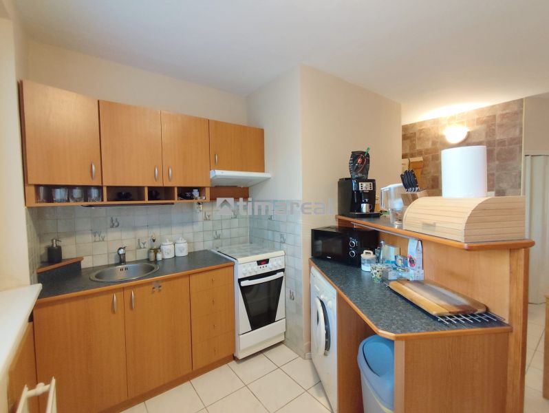 A kitchen in a 2-room apartment with a wooden decor and light tiles.