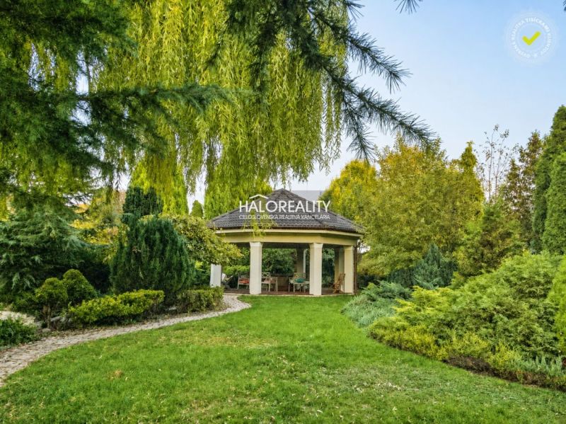 The garden of a family house in Žabokreky nad Nitrou with a gazebo surrounded by lush greenery.