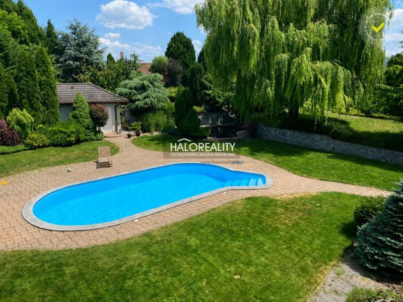 The garden of a family house in Žabokreky nad Nitrou with a swimming pool and a well-maintained lawn.