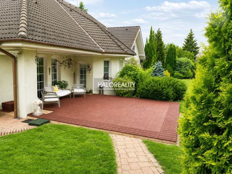 A family house in Žabokreky nad Nitrou with a terrace and a landscaped garden surrounded by greenery.