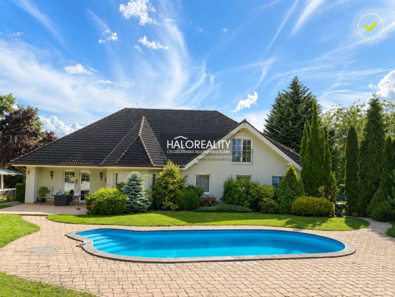 A family house in Žabokreky nad Nitrou with a swimming pool and a garden surrounded by greenery.