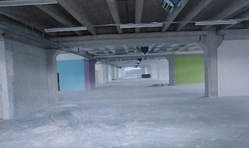 Industrial space with incomplete flooring, colorful walls, and ceilings with construction in warehouses and halls.