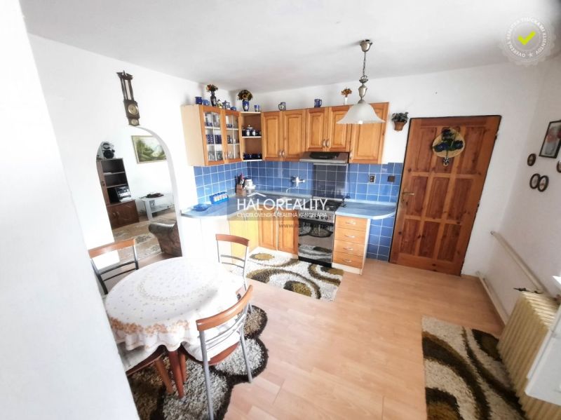 A kitchen in a family house with blue tiles and a floor with a wood decor.