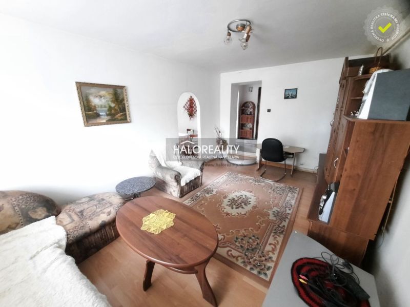 Living room in a family house with a wooden decor floor, armchairs, and a painting on the wall.