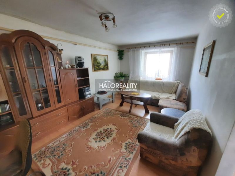 Living room in a family house with sofas, carpet, and furniture.