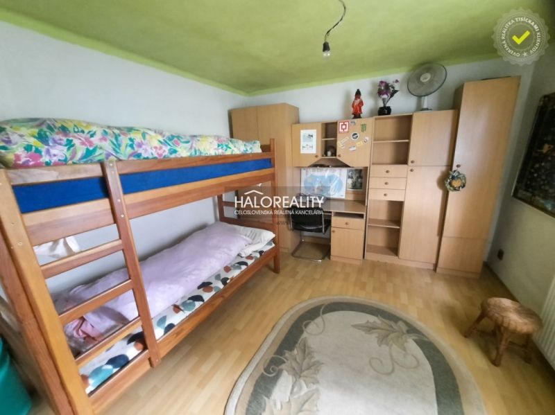A room in a family house with a bunk bed, furniture, and a wooden decor floor.