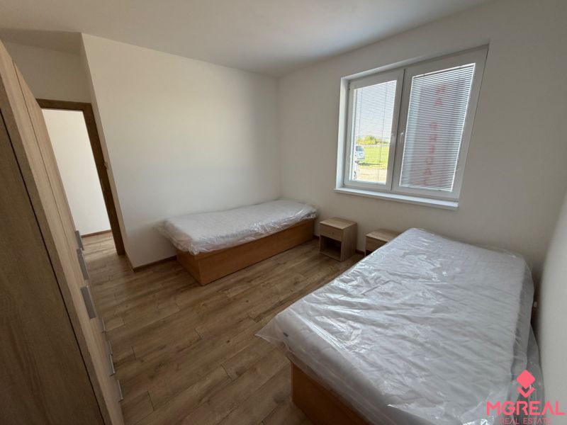 A bedroom with two beds and a wooden decor floor in a 3-room apartment.