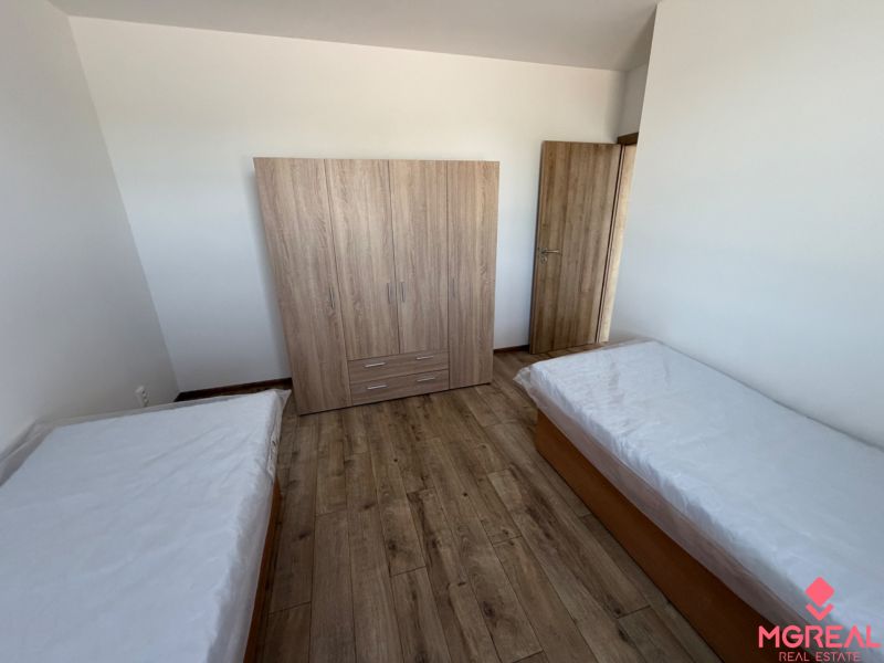 A bedroom in a 3-room apartment with a wardrobe, two beds, and a floor with a wooden decor.