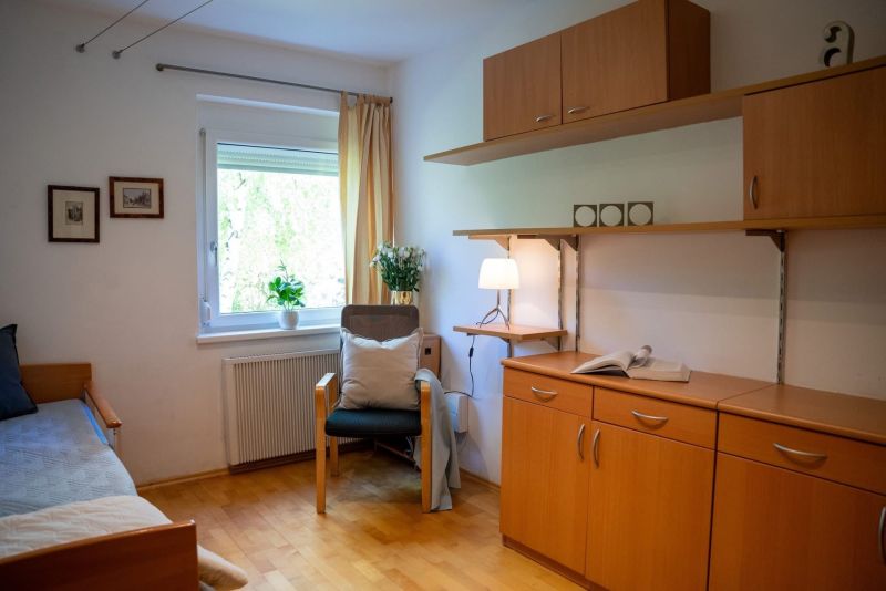 A room in a 3-room apartment with a wooden decor floor and wooden furniture.