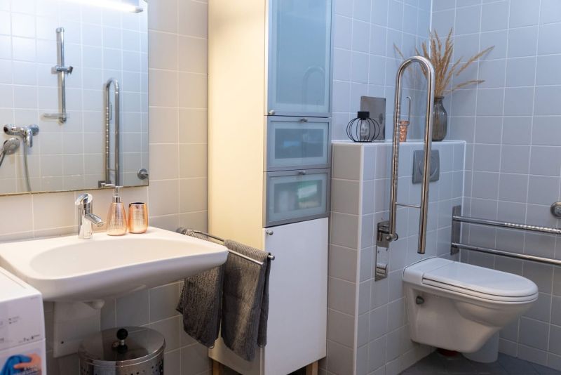 Bathroom in a 3-room apartment with a sink, toilet, and white tiles.