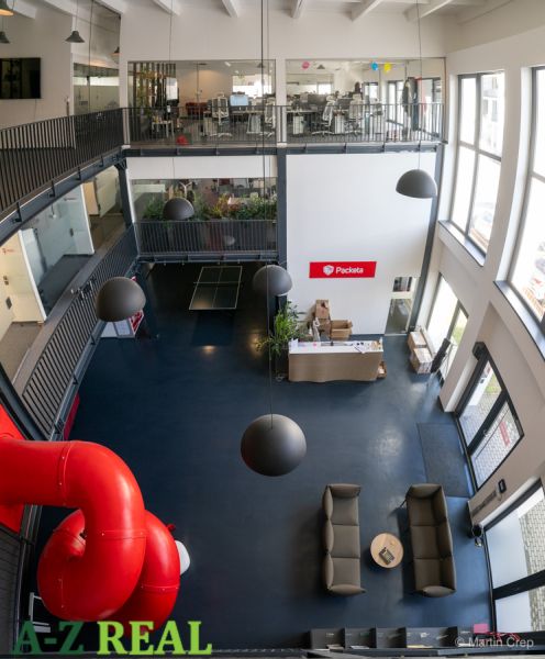 Offices with glass spaces, a staircase, and a red slide, Packeta.