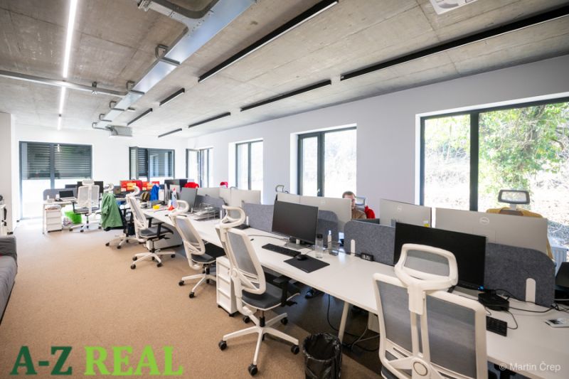 Offices with white desks and white chairs with gray backrests.