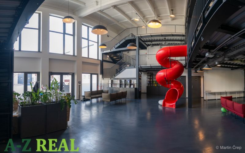 Offices with a red slide, open space, and staircase.