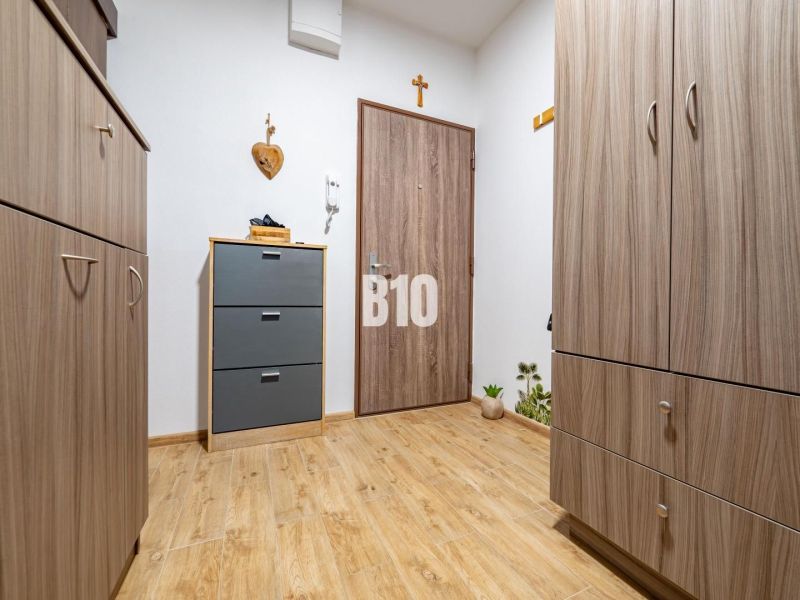 Interior of a one-bedroom apartment with a wooden decor floor and wardrobe closets.