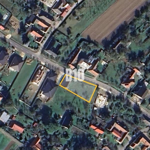 Aerial view of a residential plot in Moravské Lieskové with visible street and buildings.