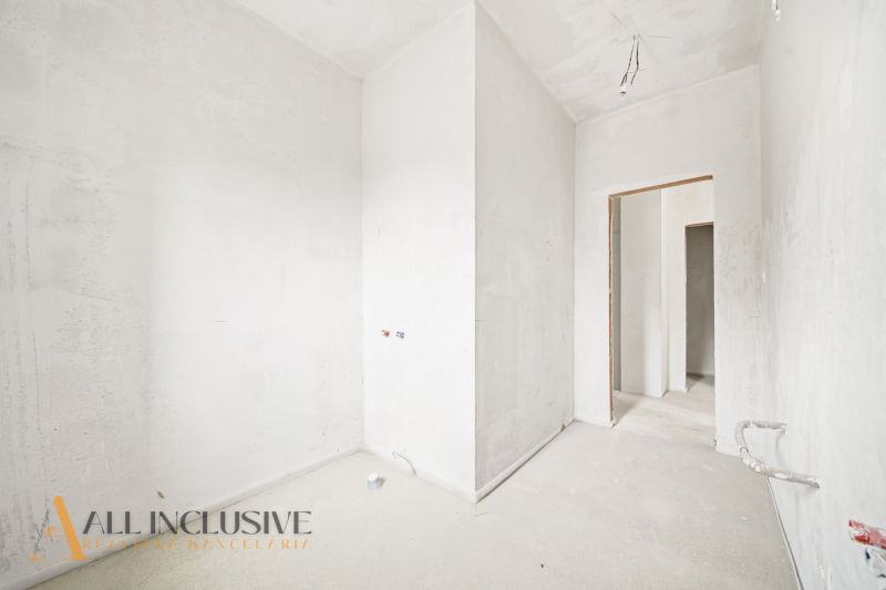 Interior of a 3-room apartment with white walls and an opening to another room.