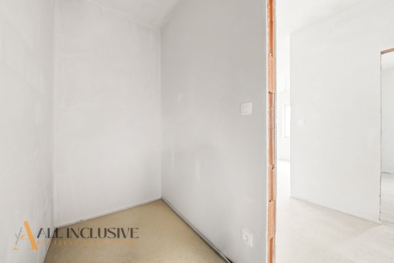 White wall and unfinished space in a 3-room apartment with flooring.
