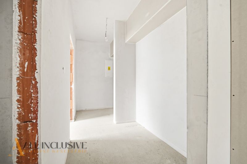 Interior of a 3-room apartment with white walls in a rough construction.