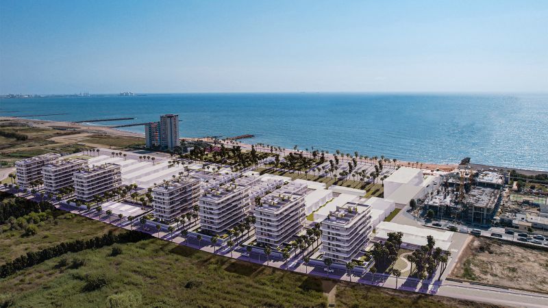 The coast with new apartment buildings and palm trees in the town of El Puig, overlooking the sea.