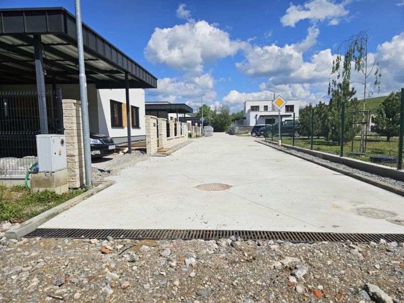 Houses on Rozbehov Street, Varín, Residential plots, next to a concrete walkway with a garden.