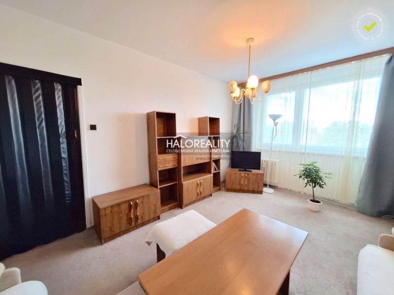 A living room with furniture and a large window in a 2-room apartment, floor with wood decor.