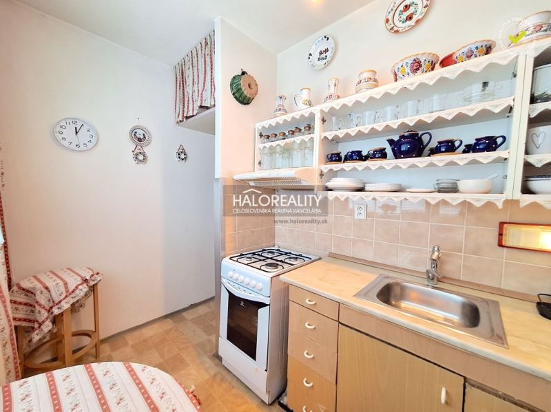 A kitchen in a 2-room apartment with a wooden decor and open shelves.