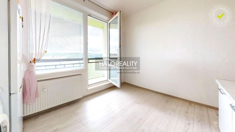 A room of a 2-room apartment with open doors and a floor with a wooden decor.