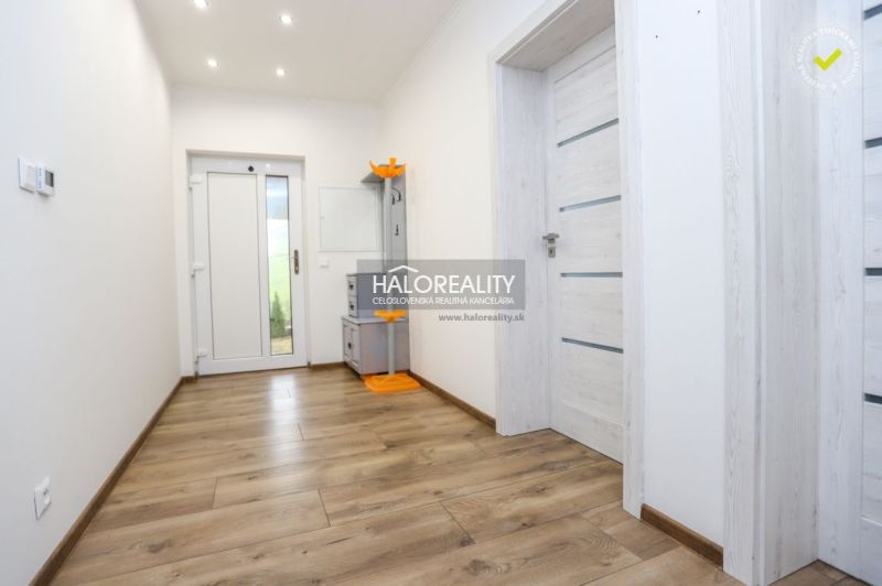 A hallway in a family house with a wooden decor floor and light-colored doors.