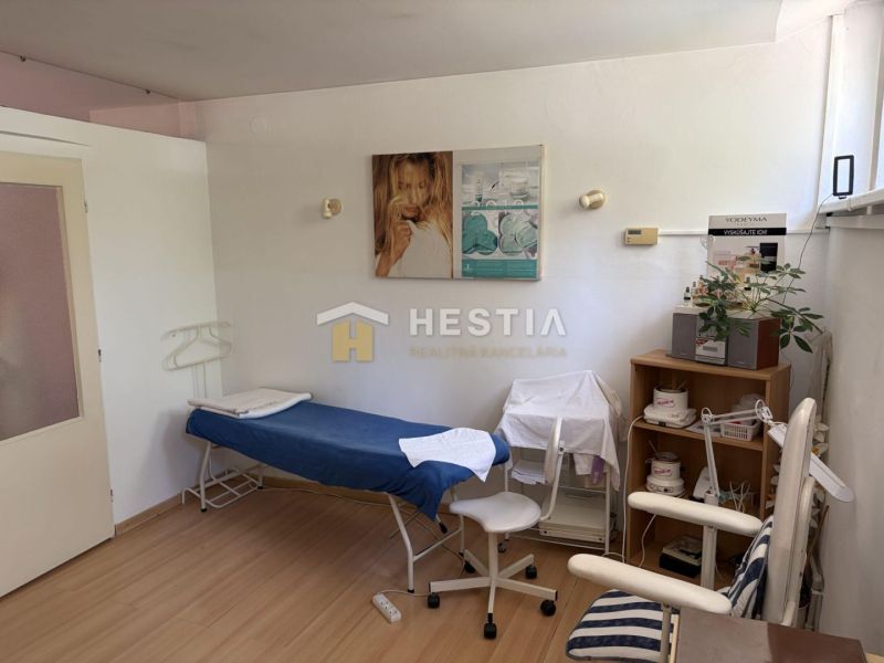 A cosmetic room with a bed, chairs, and decorations, floor with wooden decor.