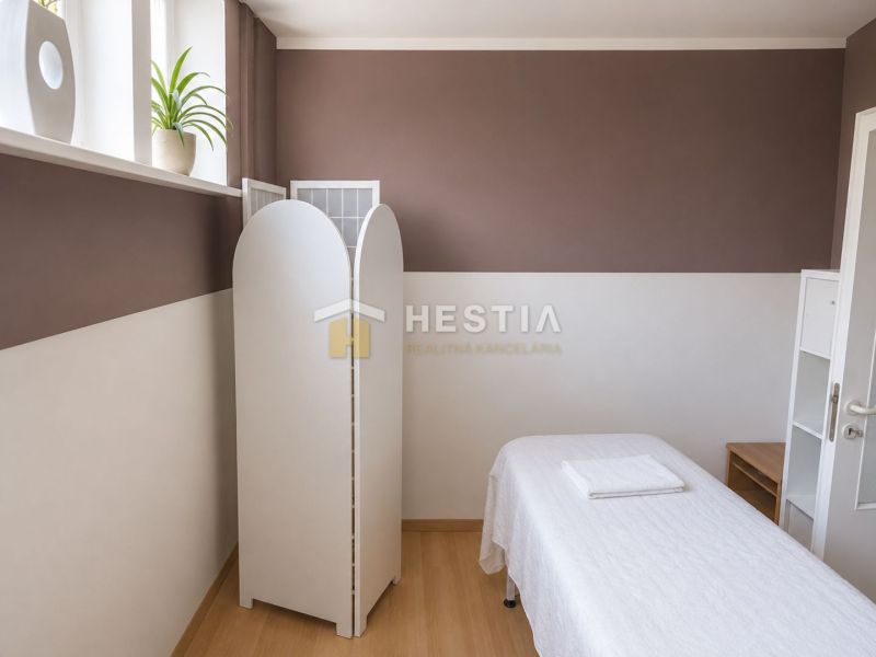 Wellness room in commercial premises with a massage table and wooden floor decor.