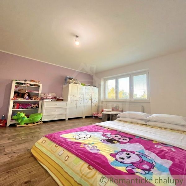 Children's room in a family house with a bed and a wooden decor floor.
