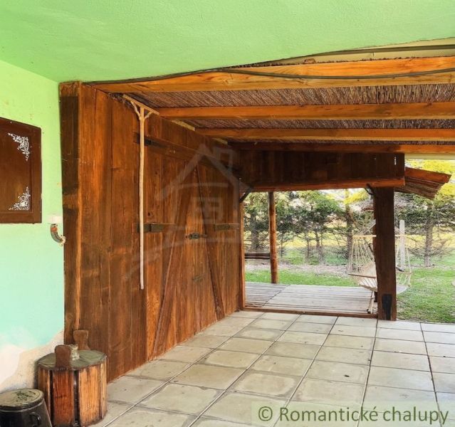 A covered terrace at a family house in Nové Hony with garden furniture and paving.