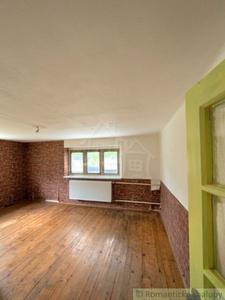 A room with brick cladding and a wooden decor floor in a family house.