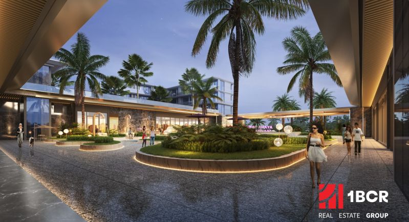 Outside the apartment construction in Phuket, palm trees and illuminated pathways can be seen.