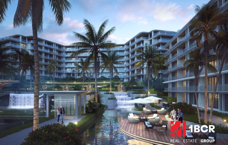 Apartment construction in Phuket with a terrace, palm trees, and an illuminated complex.