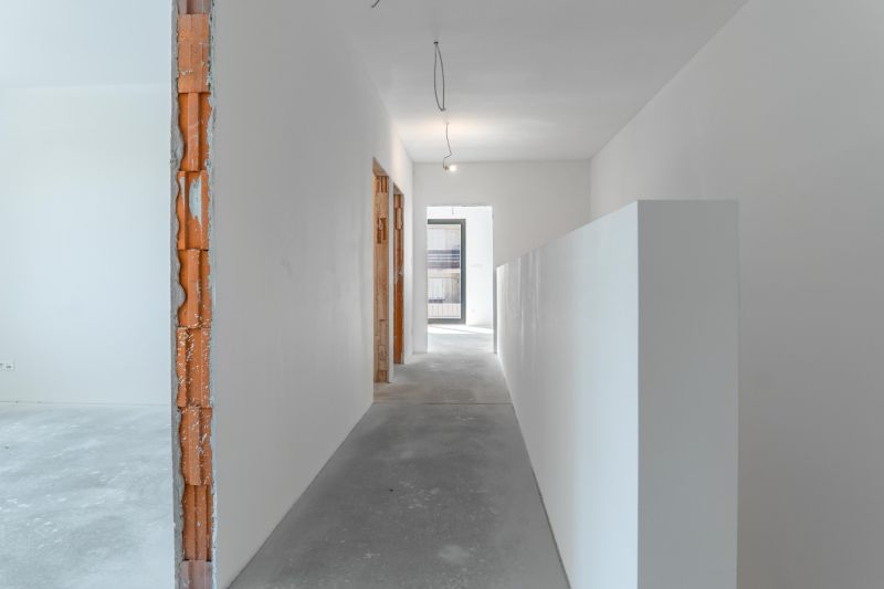 A hallway of a family house under renovation with bare walls and ceiling.