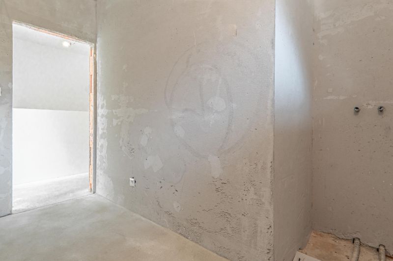 A room in a family house with bare walls and a concrete floor.
